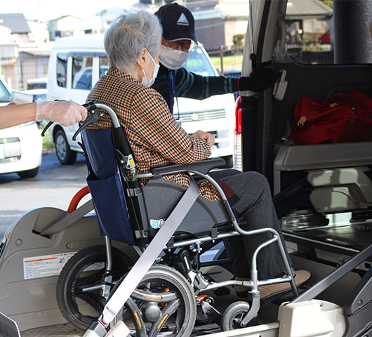 ケアハウスから送迎用の福祉車両に乗り込む様子